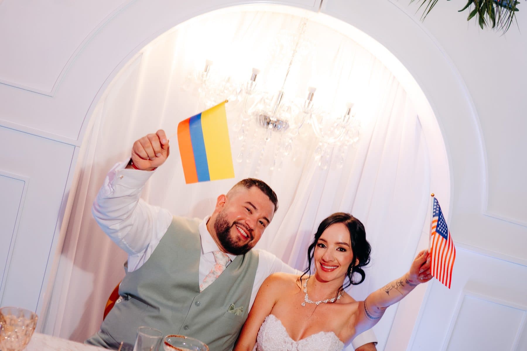 Los novios levantan las banderas de Colombia y Estados Unidos en su mesa principal