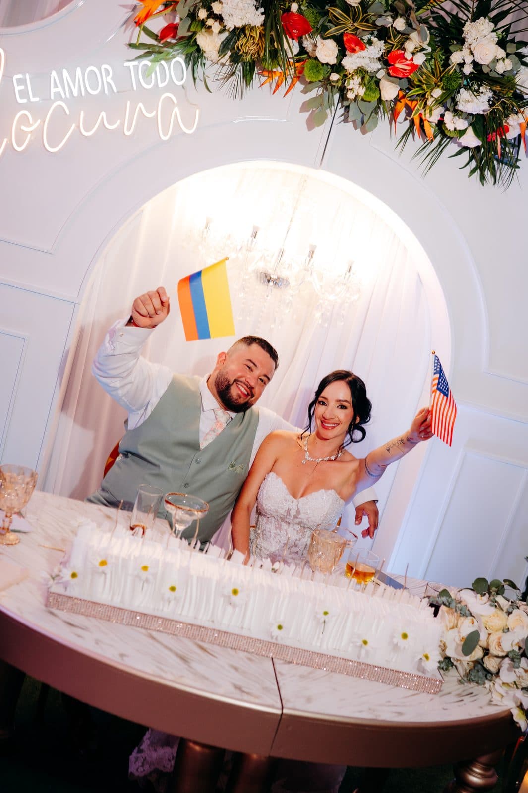 Los novios levantan las banderas de Colombia y Estados Unidos en su mesa principal