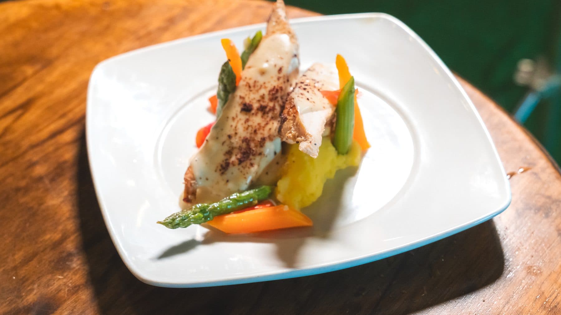 Plato fuerte servido: pechuga en salsa con espárragos, zanahoria y puré