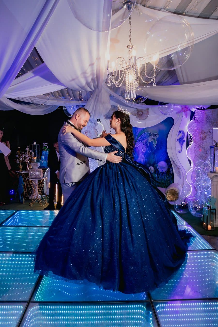 Quinceañera de vestido azul bailando el vals con su papá