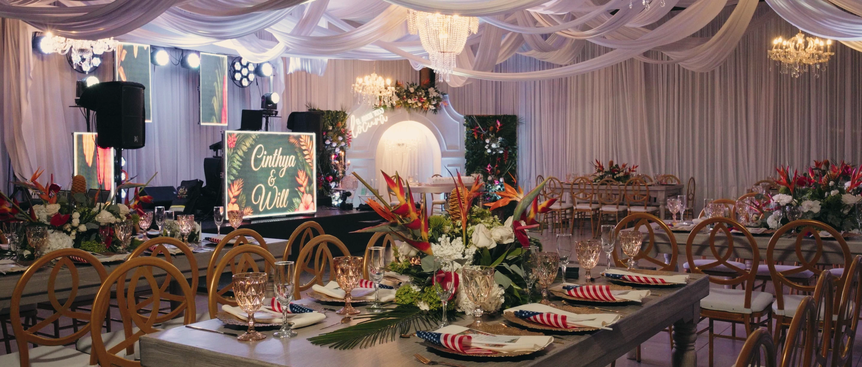 Salón de una boda Altagracia con las mesas montadas y flores tropicales